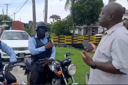 Leader of the Opposition Aubrey Norton questioning the policemen who were trailing him.