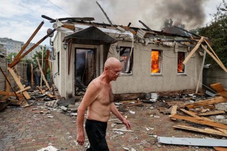A local resident walks, as his neighbour's house burns after shelling in Lysychansk, Luhansk region Ukraine June 2, 2022. REUTERS/Serhii Nuzhnenko 