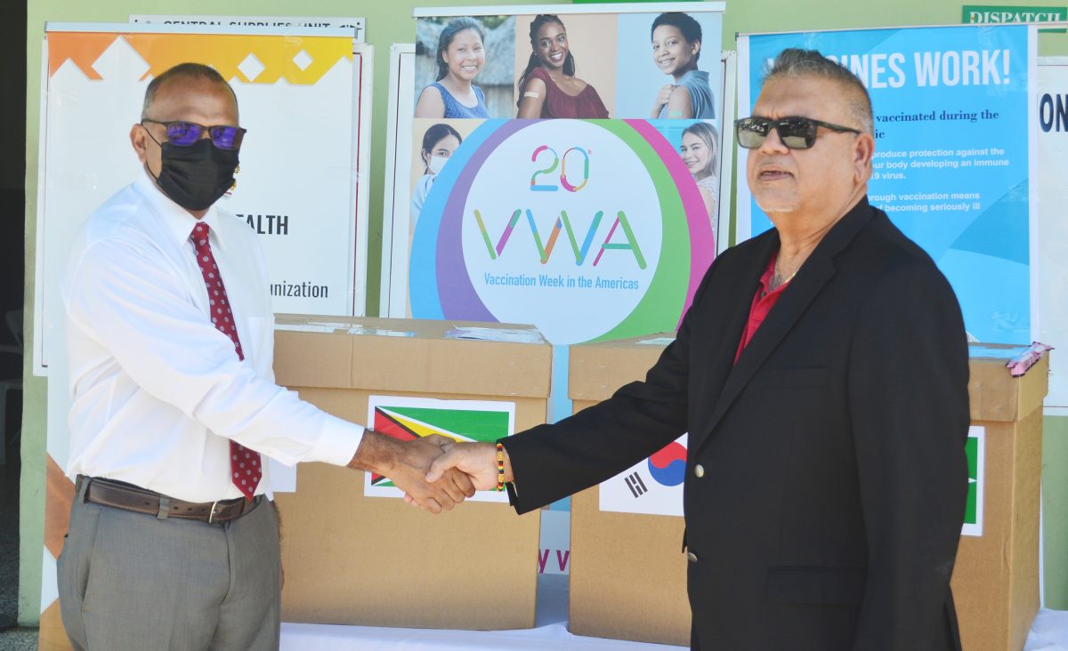 Minister of Health, Dr Frank Anthony and the Honorary Consul of the Republic of Korea Ramesh Dookhoo, shaking hands after the handing over of the Moderna COVID-19 vaccines on Friday at the MoH bond in Kingston 