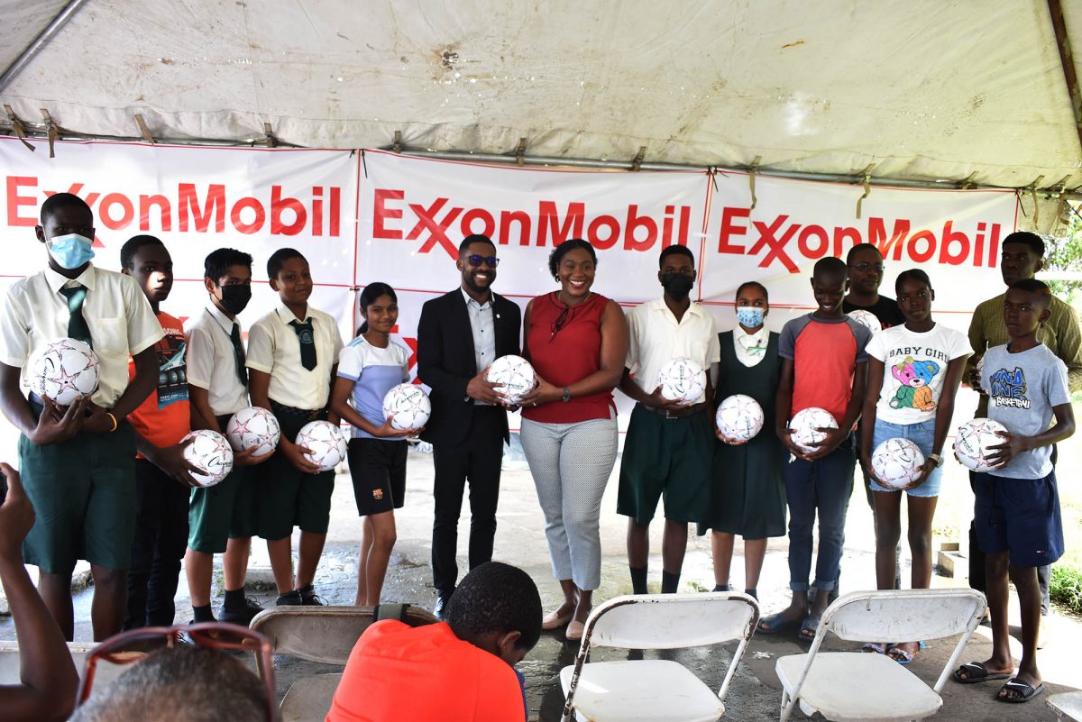 Petra Organization senior member Jacklyn Boodie, receiving the ceremonial ball from Ryan Hoppie, ExxonMobil Community Relations Advisor, in the presence of representatives from the competing teams