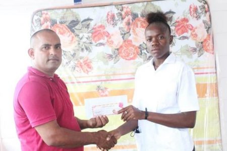 Inspector Sohan Ramdat, Chairman of the Police Association, making the official presentation to Lance Corporal Alpha Daniels (Guyana Police Force photo)