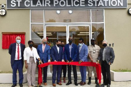 Prime Minister Dr Keith Rowley, fourth from right—in the company of ministers, acting Commissioner of Police McDonald Jacob, second right, Port of Spain Mayor Joel Martinez, third from left, and officials from the Urban Development Corporation of Trinidad and Tobago—cuts the ribbon to officially open the new St Clair Police Station at Serpentine Road, St Clair