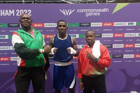 Amsterdam, flanked by Coaches Terrence Poole (first from left) and Sebert Blake following his victory at the Commonwealth Games. 