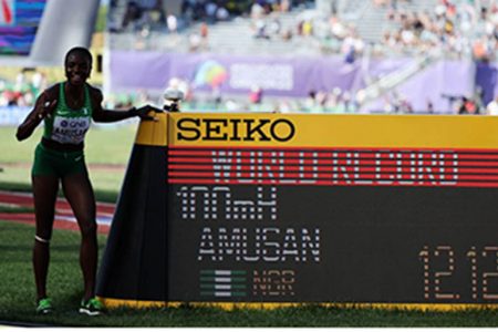 Nigeria’s Tobi Amusan poses with a time board as she celebrates after setting a new world record and winning her semi final yesterday. REUTERS/Lucy Nicholson