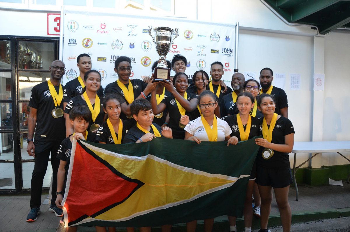 Title reclaimed - Team Guyana posing with the overall championship, the 13th in their history, after securing the Boys and Girls team crowns in the 2022 Junior CASA