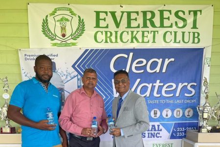 Ricky Lucknauth (centre) makes the presentation of 20 cases of Clear Waters to Manzoor Nadir (right)  Tuesday while Clear Water Salesman, Euford Saul looks on.