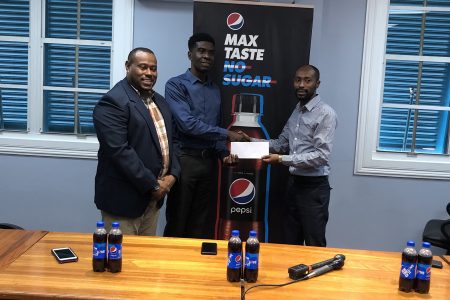 Larry Wills (left), Pepsi Brand Manager, hands over the sponsorship to Petra Organization member Mark Alleyne in the presence of Co-Director Troy Mendonca
