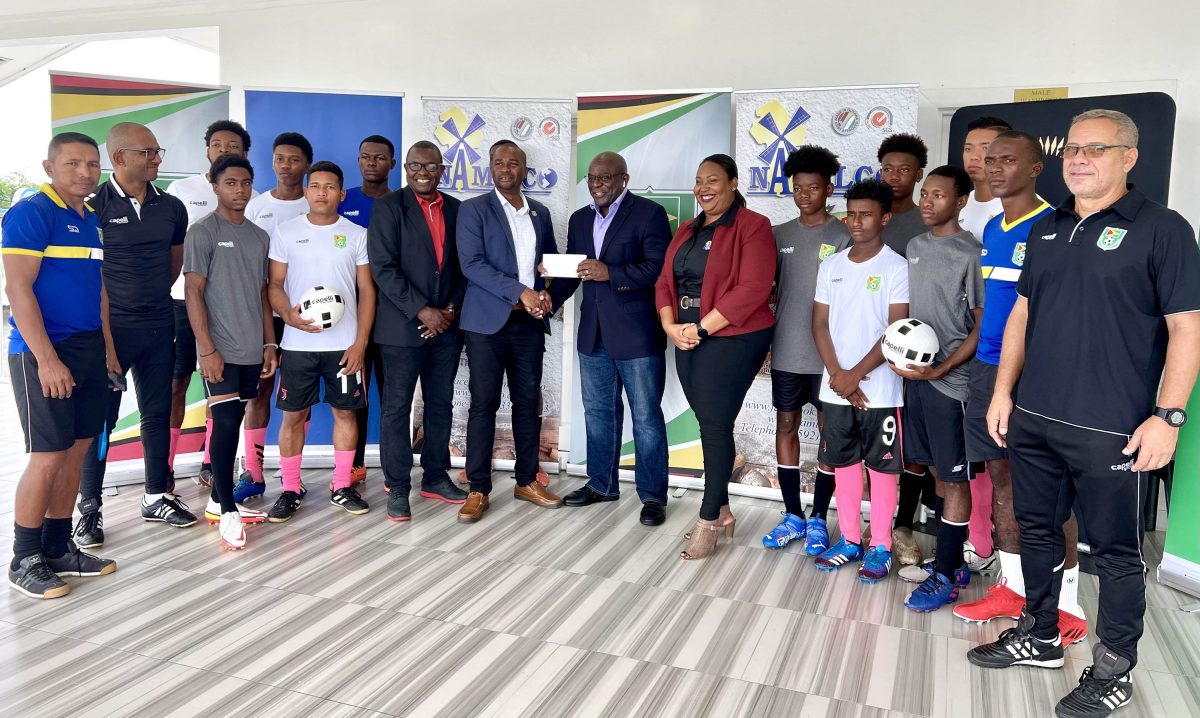 Namilco Finance Controller Fitzroy McLeod (centre) hands over the sponsorship cheque to GFF President Wayne Forde in the presence of officials and players at the launch of the NAMILCO Thunderbolt Flour Power National Under-17 League.