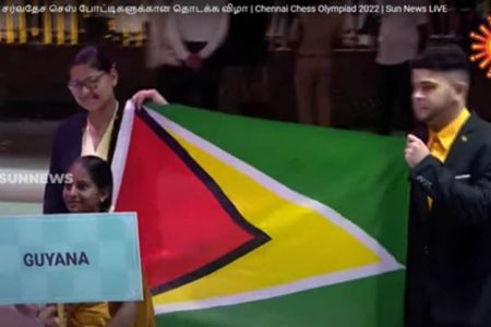 Guyana’s Pooja Lam and Roberto Neto carring the Golden Arrowhead at the opening of the 44th Chess Olympiad in Chennai, India.