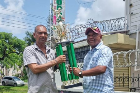 Essequibo Cricket Board Vice-President, Elroy Stephney (right) receives the first place trophy from Ramesh Sunich of Trophy Stall.