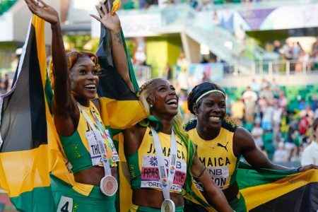 Gold medalist Shelly-Ann Fraser-Pryce, of Jamaica, center, stands with silver medalist Shericka Jackson, of Jamaica, right, and bronze medalist Elaine Thompson-Herah, of Jamaica, wave after a medal ceremony for the final in the women's 100-meter run at the World Athletics Championships on Sunday. (AP)