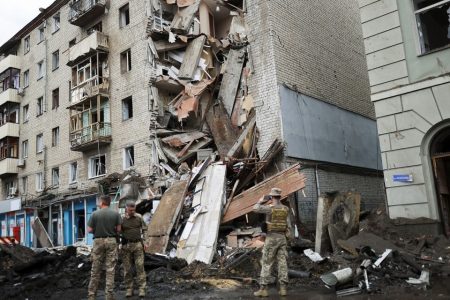 Ukrainian servicemen stand in front of Valentina Popovichuk's flat, where she was rescued after Russian shelling in a military strike, as Russia's invasion of Ukraine continues, in Kharkiv, Ukraine, July 11, 2022. REUTERS/Nacho Doce