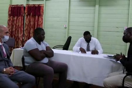 Rondell Bacchus (second, from left) during a visit at the CID Headquarters after a wanted bulletin was issued for him in relation to the murder of Ricardo Fagundes. The police said he was accompanied by his lawyer (seated at left). (Guyana Police Force photo)
