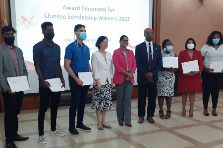 The 2022 China scholarship awardees pose for a photo with (fifth from left), Ambassador of the People’s Republic of China to Guyana, Guo Haiyan; Minister of Public Service, Sonia Parag (sixth from left); and  Director of the Department of International Cooperation, Forbes July (seventh from left).