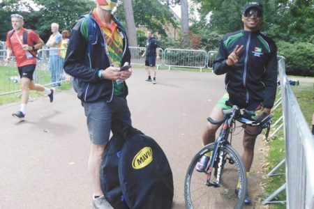 Guyana’s lone cyclist at these Commonwealth Games, Christopher Griffith, will aim to impress on the saddle today in the men’s road race. Pictured next to Griffith is his coach Shaun Green
