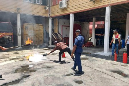 Ministry of Education security personnel being taught how to use a fire extinguisher. (GFS photo)
