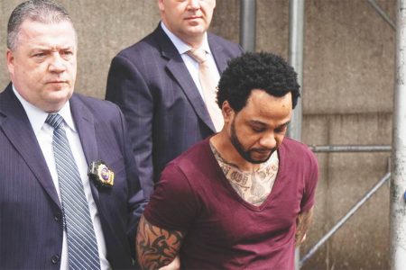 Troy Thomas is pictured being escorted from 109th Precinct in Queens following his arraignment in April, 2019
