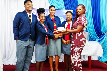 Director of NCERD,  Quenita Walrond-Lewis (right) presenting the prize to the CPCE students who created “Home Work Helpers”, the most innovative AI project. (Ministry of Education photo)

