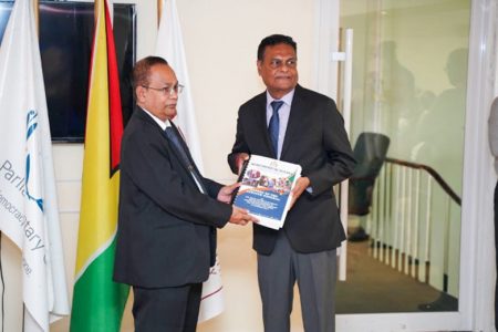 Auditor General Deodat Sharma (at left) hands over a copy of the 2021 Auditor’s General report and five performance audit reports to Speaker of the National Assembly Manzoor Nadir (DPI photo)
