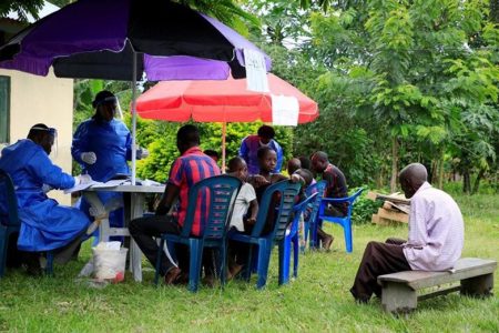 Ugandan health workers speak to members of the community before carrying out the first vaccination exercise against the ebola virus in Kirembo village, near the border with the Democratic Republic of Congo in Kasese district, Uganda June 16, 2019. REUTERS/James Akena