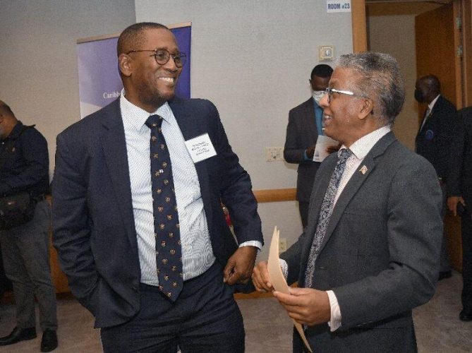 Chief Justice Ivor Archie, left, chats with Attorney General Reginald Armour during yesterday’s opening of the Caribbean Court of Justice’s first hemispheric meeting of regional courts, “The Rule of Law and International Justice”, at the Hyatt Regency, Port of Spain.