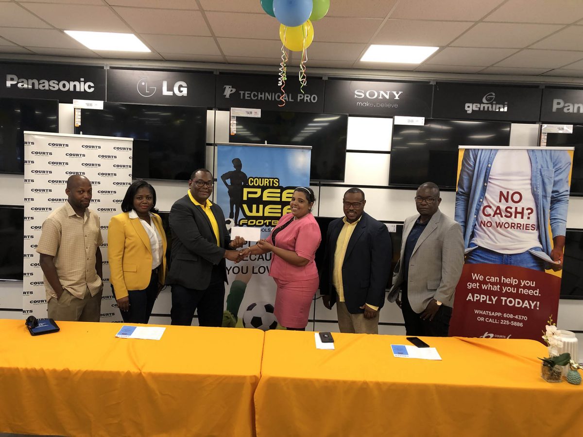 Petra Organization representative Nareeza Latif receiving the sponsorship cheque from Richard Allan, Courts Director of Consumer Finance, at the official launch of the Courts Pee Wee Boys U11 Football Championship. Also in the photo are (1st from left) Kurt Brathwaite, Ministry of Education representative; (2nd from right) Petra Organisation Co-Director Troy Mendonca, and (1st from right) Bryan Joseph, Guyana Football Federation Technical Director