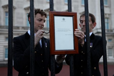 Personnel place a sign announcing the death of Queen Elizabeth on a fence outside the Buckingham Palace, after Queen Elizabeth, Britain's longest-reigning monarch and the nation's figurehead for seven decades, died aged 96, according to Buckingham Palace, in London, Britain September 8, 2022. (Reuters photo)