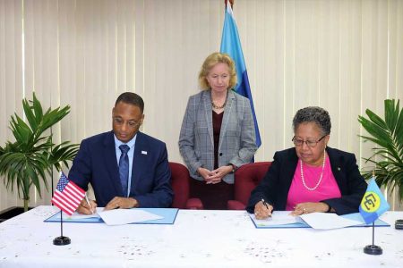 CARICOM Secretary General Carla Barnett (right) and USAID’s Clinton D White signing the agreement. US Ambassador Sarah-Ann Lynch is at centre. (US Embassy photo)