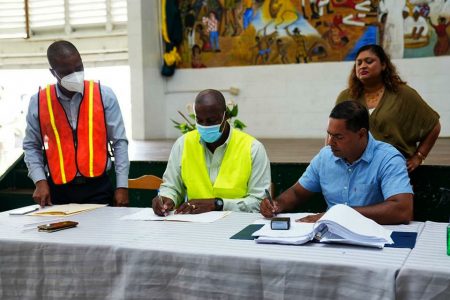The contract signing on August 24th. The owner of Kares, Radesh Rameshwar is at right. Minister of Education Priya Manickchand is standing in the background (Ministry of Education photo)