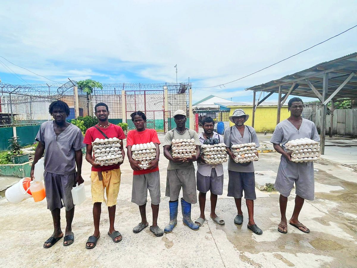 Inmates with some of the eggs produced at the prison (Ministry of Home Affairs photo)