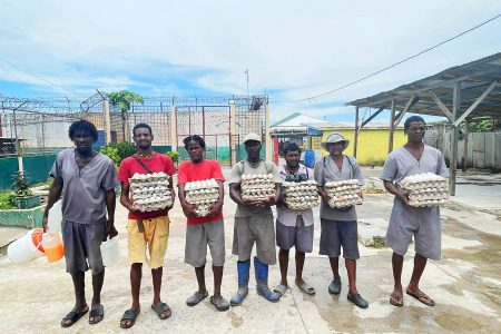 Inmates with some of the eggs produced at the prison (Ministry of Home Affairs photo)