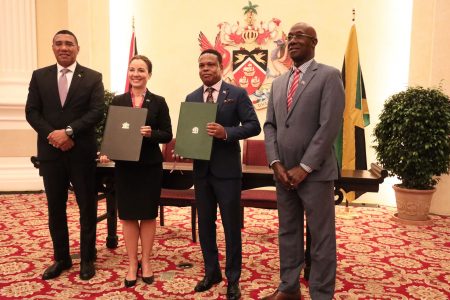 Jamaica Prime Minister Andrew Holness (left) and Prime Minister Dr Keith Rowley (right) pose for a picture with Jamaica Foreign Affairs Minister Kamina Johnson Smith (second from left) and Foreign Affairs Minister Dr Amery Brown holding the Memorandum of Understanding on trade matters after the signing ceremony at the Diplomatic Centre, St Ann’s, on Monday.