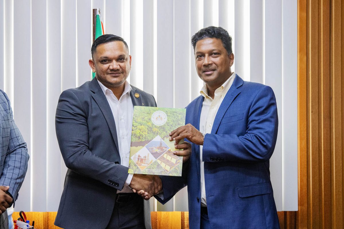 Minister of Natural Resources  Vickram Bharrat (left) handing over an approved Local Content Master Plan to the Country Lead of Halliburton Guyana, Vahman Jurai. (MNR photo)
