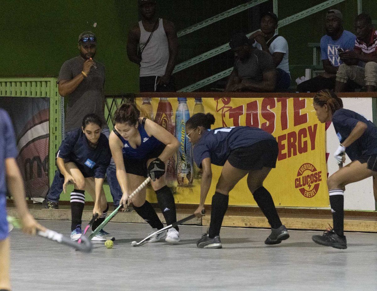 Madison Fernandes (centre) of GCC Spartans battling to keep possession of the ball in the Lucozade Indoor Hockey Championship