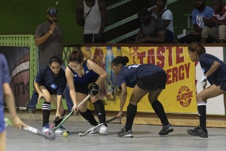 Madison Fernandes (centre) of GCC Spartans battling to keep possession of the ball in the Lucozade Indoor Hockey Championship