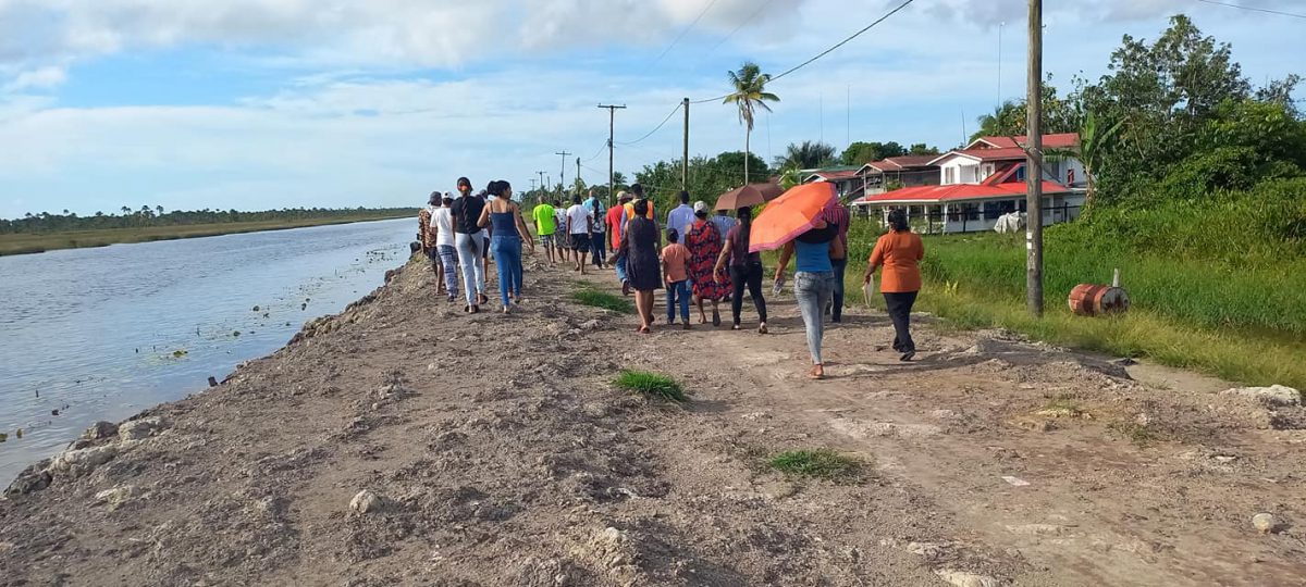 The minister and residents  walking on the conservancy dam
