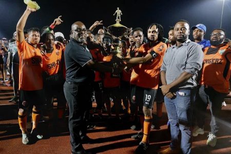 Slingerz captain Quincy Adams collecting the championship trophy from GFF Vice President Rawlston Adams
in the presence of teammates and WDFA President Trevor Williams 