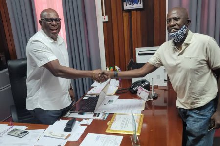 Former Caribbean men’s singles champion Sydney Christophe greets Director of Sport, Steve Ninvalle at his Middle Street Office on Tuesday.