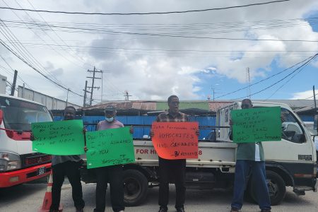 Elton McRae and other Beterverwagting residents protesting at the John Fernandes Limited wharf yesterday.
