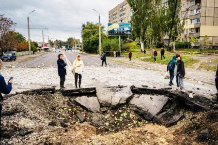 Local residents examine a crater following a missile strike in Dnipro, Ukraine. Credit: AFP Photo