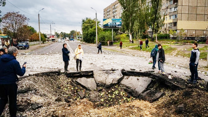 Local residents examine a crater following a missile strike in Dnipro, Ukraine. Credit: AFP Photo