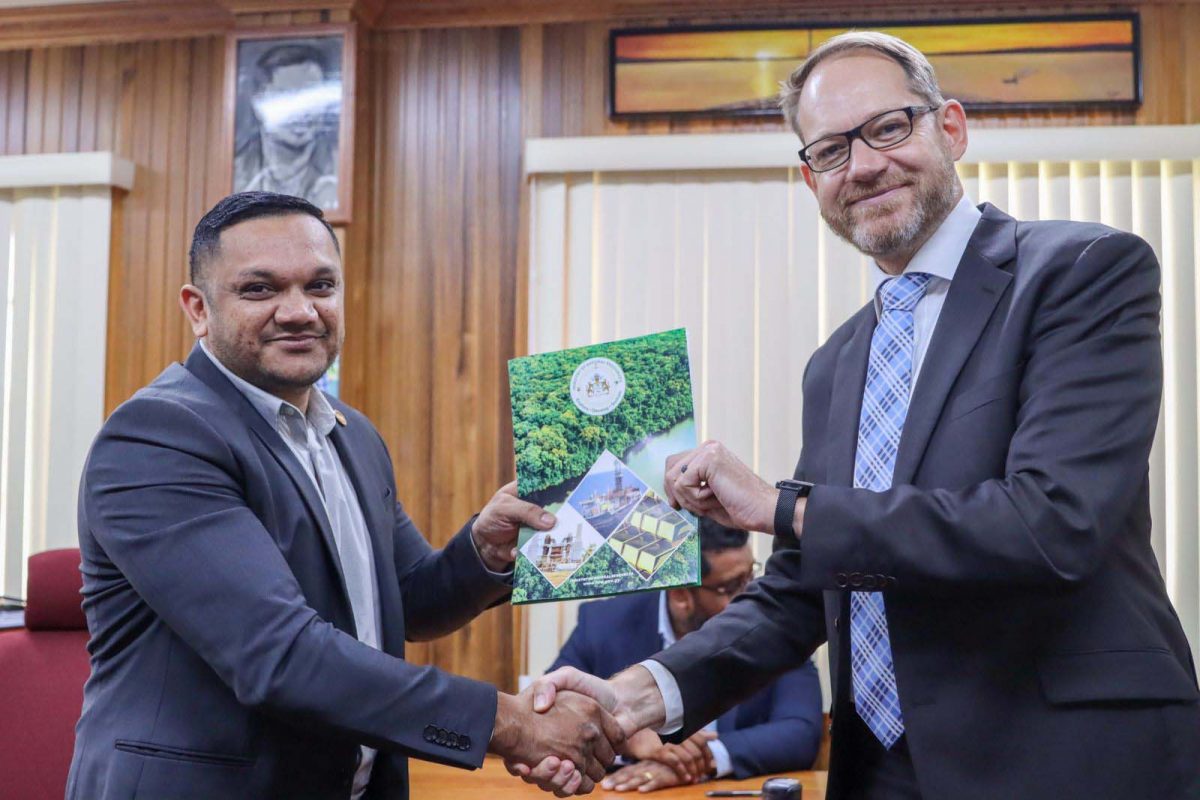 Minister of Natural Resources Vickram Bharrat (at left) hands over an approved Local Content Master Plan to the Area Director of TechnipFMC Nicolas Sicard (Ministry of Natural Resources photo) 