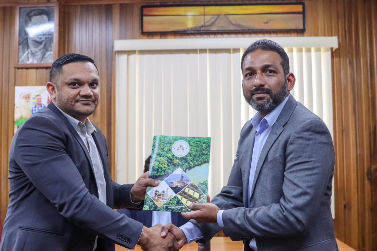 Deputy General Manager of Guyana Shore Base Inc, Rabin Chandarpal (right), receives the Local Content Master Plan Approval from Minister of Natural Resources, Vickram Bharrat.  (GYSBI photo)