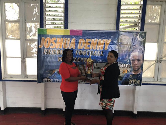 Nareeza Latif (right) of the Petra Organization presents the trophy to tournament organizer Aferya Denny.