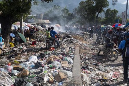 People move through a street covered with garbage that has not been collected in Port-au-Prince, Haiti, on Oct 8, 2022. PHOTO: EPA-EFE