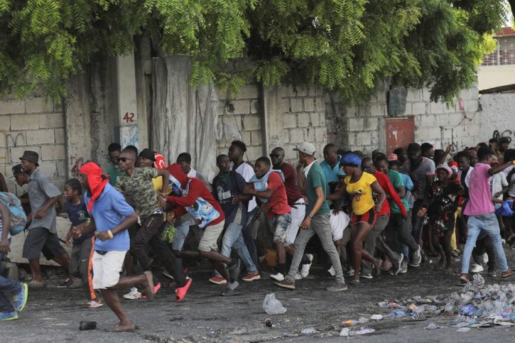 People walk away after hearing gunshots during a protest demanding the resignation of Haiti's Prime Minister Ariel Henry after weeks of shortages, in Port-au-Prince, Haiti October 10, 2022. REUTERS/Ralph Tedy Erol