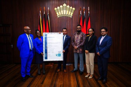 G-Invest CEO Dr Peter Ramsaroop (fourth from right) displaying the certificate. President Irfaan Ali is third from right. (Office of the President photo)