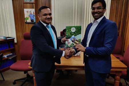 Director of GESGI Jodel Gopeesingh (right) receiving the approved plan from Minister of Natural Resources, Vickram Bharrat. (Ministry of Natural Resources photo)
