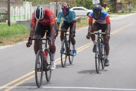 Team Foundation’s Jamual John crosses the tape ahead of breakaway mates, Andre Green (Kaieteur Attack Racing) and Briton John (Team United) to earn the ounce of gold in the Urban Benjamin Memorial road race yesterday in Essequibo. (Emmerson Campbell photo) 
