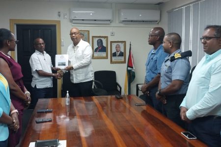 Minister of Public Works Juan Edghill (centre) receiving the report from Captain Joseph Lewis (Ministry of Public Works photo)